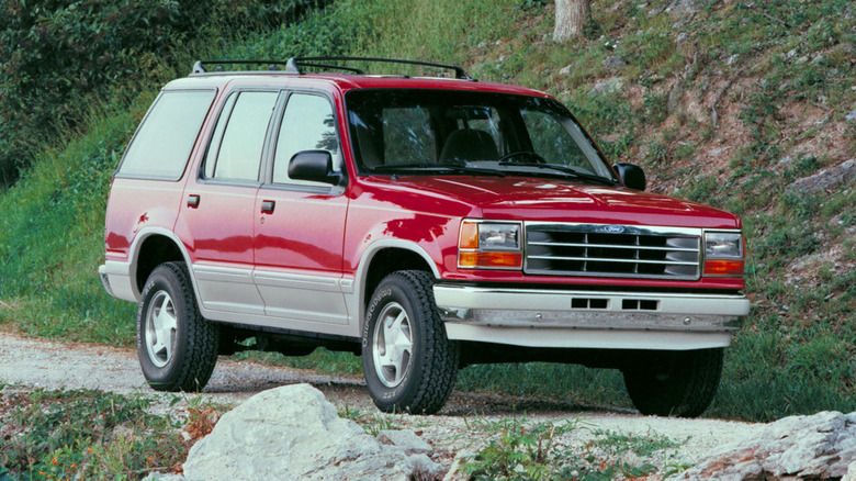 Красный Ford Explorer 1991 года выпуска, вид спереди в 3/4 на горной тропе.