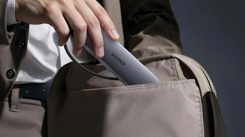 Человек, несущий в сумке концентратор Anker USB-C.