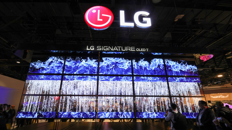 Несколько OLED-телевизоров LG расположены на дисплее так, чтобы под массивным логотипом LG и текстом был виден каскад воды. 