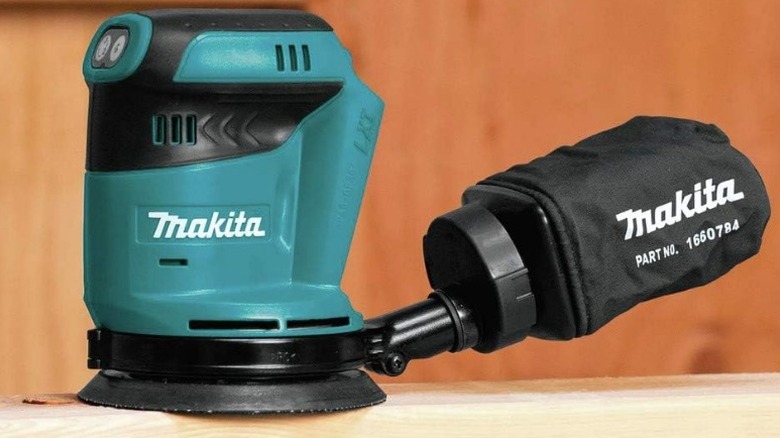 Шлифовальная машина Makita, сидящая на дереве