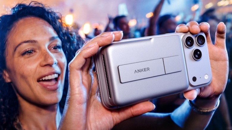 Женщина держит iPhone с подключенным Anker MagGo Power Bank 2 Pro