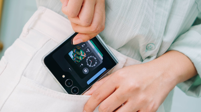 Человек кладет телефон Samsung Galaxy Z Flip7 в карман