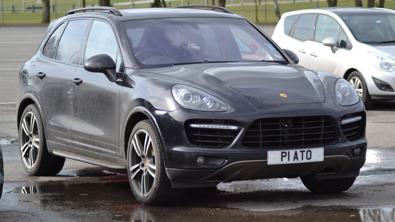 Porsche Cayenne второго поколения припаркован на стоянке, вид спереди справа в 3/4