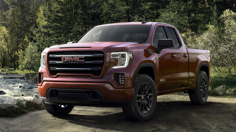 Красный грузовик GMC Sierra Elevation 2019 года припаркован возле реки.