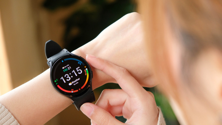 человек трогает Galaxy Watch