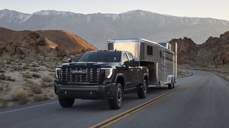 GMC Sierra HD 2027 года буксирует прицеп для перевозки лошадей