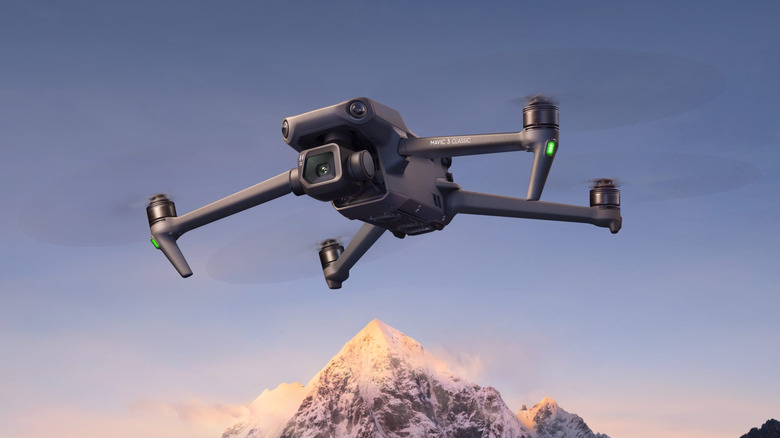 DJI Mavic 3 Classic летит в воздухе на фоне горы