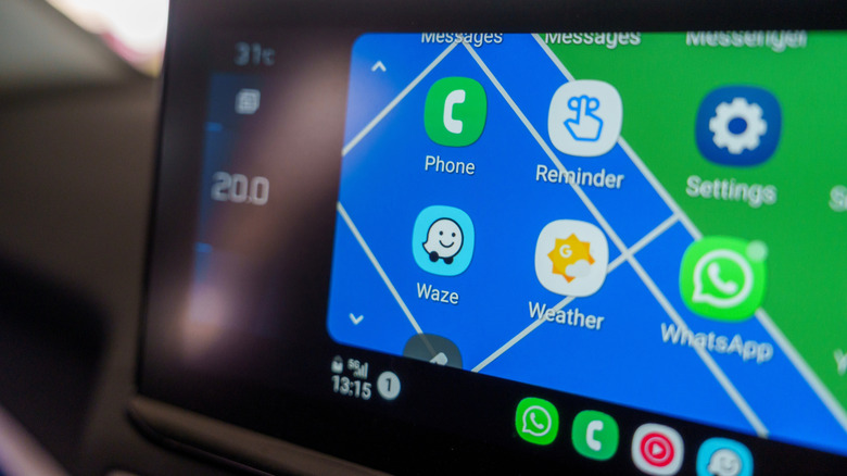 Интерфейс Android Auto, показывающий Waze и WhatsApp среди других приложений на головном устройстве автомобиля.