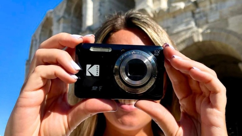 женщина целится в цифровую камеру Kodak PIXPRO FZ55