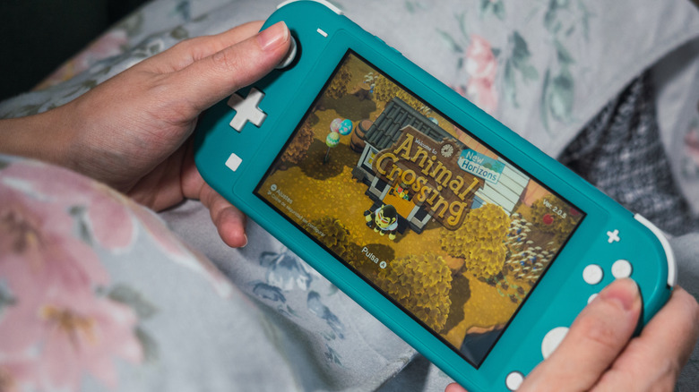 женщина играет в «Пересечение животных» на Nintendo Switch Lite