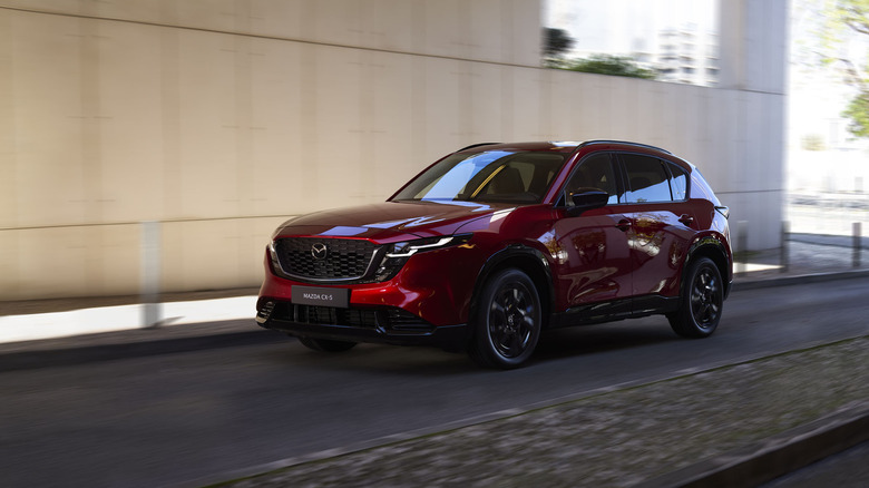 Mazda CX-5 2026 года в красном цвете едет по городской дороге