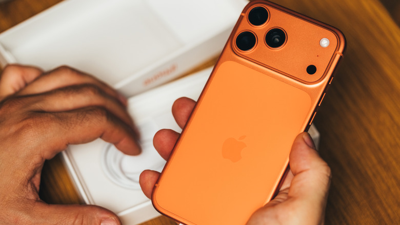 Оранжевый iPhone 17 распаковывают.