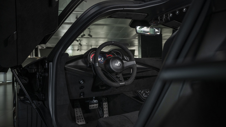 Крупным планом кабина водителя Alfa Romeo 33 Stradale Perla Nero с открытой дверью
