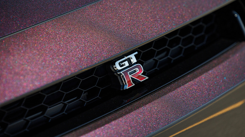 Крупный план значка GT-R на R35 цвета Midnight Purple.