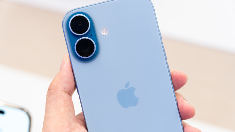 крупный план руки, держащей мятно-синий iPhone 17
