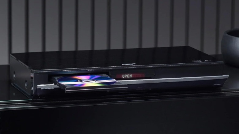 Blu-ray-плеер Panasonic DP-UB820-K с открытым лотком для дисков на черной полке