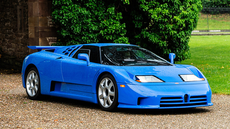 Bugatti EB 110 1992 года, припаркованный у подъезда к загородному дому, вид спереди справа в 3/4