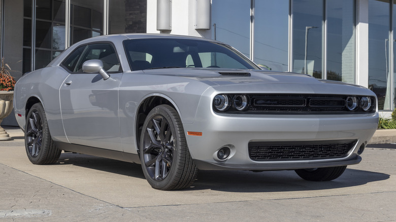 Серебристая базовая модель Dodge Challenger SXT припаркована снаружи.