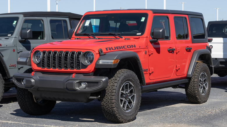 Красный Jeep Wrangler Rubicon припаркован на стоянке Jeep Wrangler.