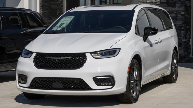 Белый Chrysler Pacifica припаркован перед автосалоном.
