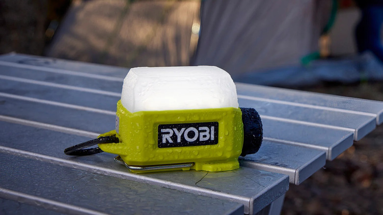 Литиевый светильник Ryobi USB на уличном столе под дождем