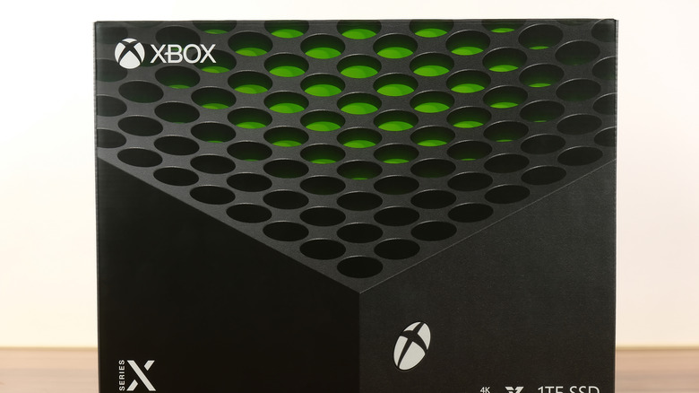 коробка для Xbox Series X, расположенная на деревянной поверхности на белом фоне