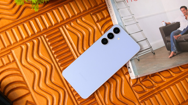 Синий телефон Samsung рядом с книгой.