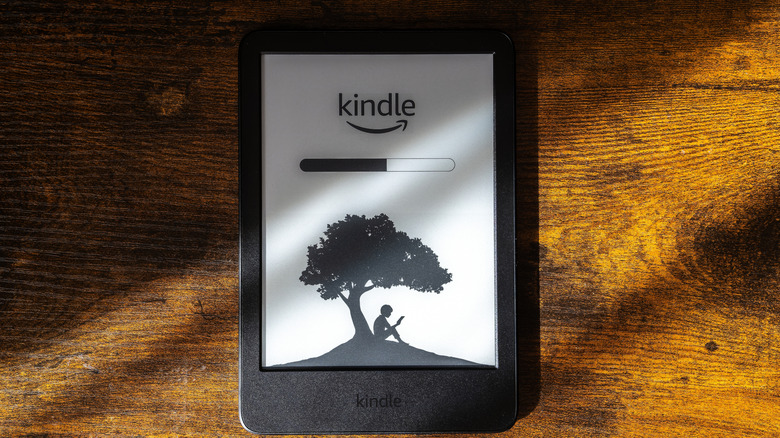 Kindle лежит на деревянном столе с загрузочным экраном