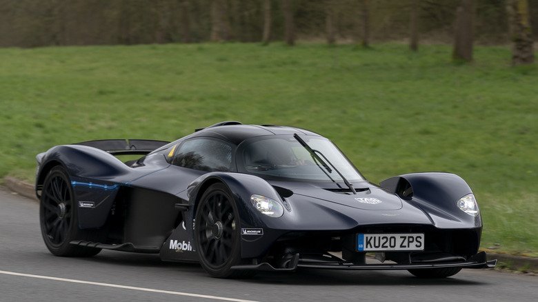 Вид спереди в 3/4 на Aston Martin Valkyrie, едущий по дороге общего пользования