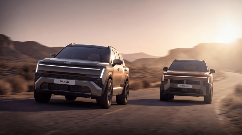 Две модели Hyundai Tuscon 2027 года едут бок о бок по пустынной дороге, вид спереди