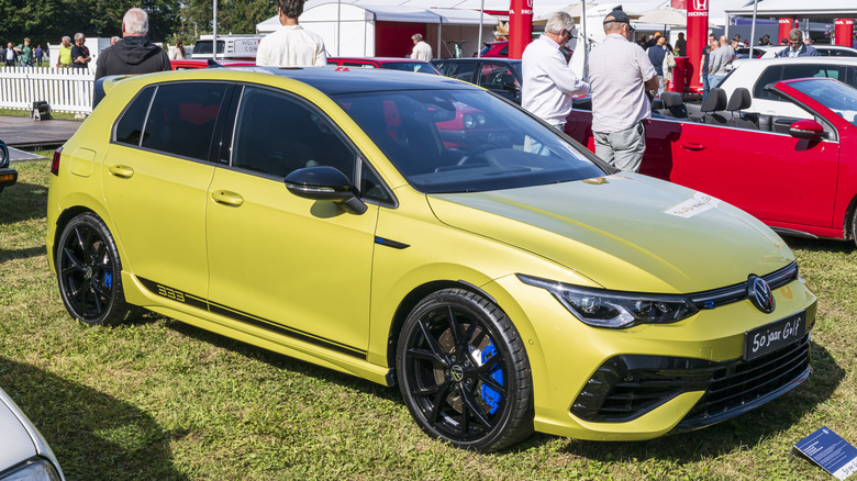 Ярко-желтый Volkswagen Golf R, припаркованный на лужайке.