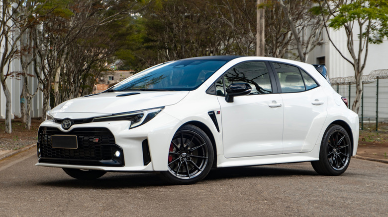 Снаружи припаркована белая Toyota Corolla GR.
