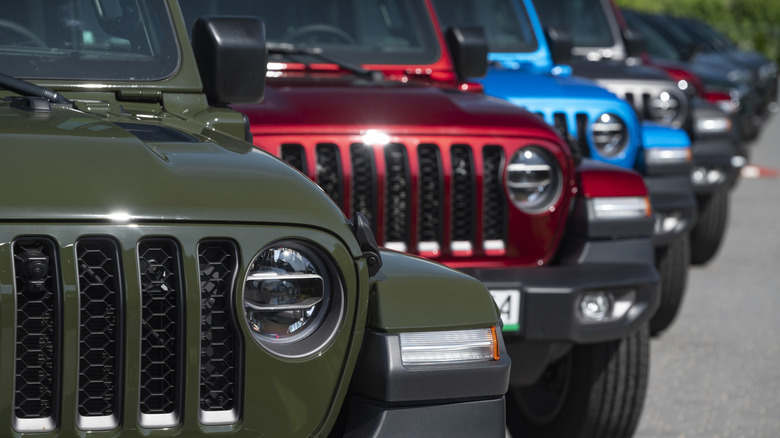 Ряд нескольких Jeep Wranglers, припаркованных рядом друг с другом.
