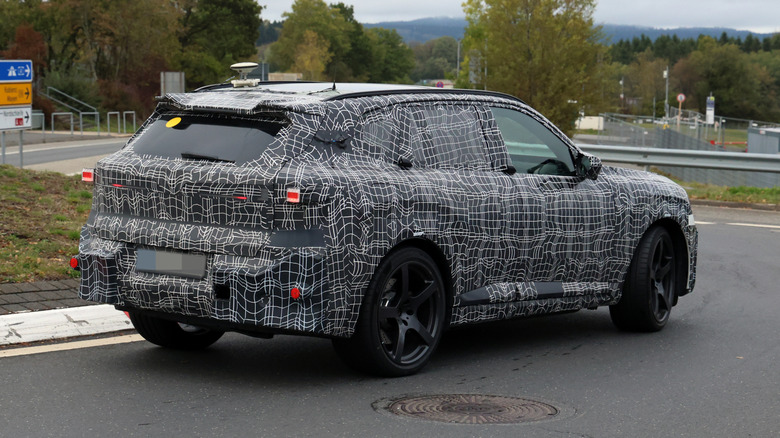 Замаскированный BMW X5 M едет по дороге общего пользования.
