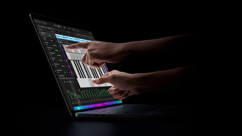 Человек, играющий на виртуальном пианино на экране MacBook Pro.